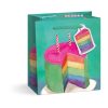 Vibrant colorful rainbow cake inside a decorative shopping bag with birthday candles and tag at The Wraperie for celebration gift wrapping services.