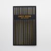Elegant black birthday greeting card with gold foil vertical stripes and vibrant orange text reading "Lovely Friend, Happy Birthday." Perfect for celebrating special friendships with stylish, premium stationery.