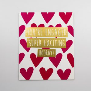 Engagement announcement sign with hearts, "You're engaged super exciting hooray" message, wedding celebration decor, romantic event signage, love celebration indication.