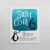 Blue metallic birthday card with penguin graphic and text "Super Cool 6 Happy Birthday", colorful fun greeting card for 6th birthday, cute animal design, celebration message, kids birthday card, cheerful greeting card, children's party invite.