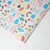 Bright, colorful printed wrapping paper featuring playful unicorns, rainbows, smiley faces, and positive phrases like "Hooray," "Have Fun," and "So Cool" from The Wraperie, perfect for celebrating and gift wrapping.