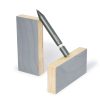Black fine-tip pen balanced on two wooden blocks with gray and natural finishes, showcasing creative design and stationery products for office and art supplies.