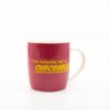 Bright pink coffee mug with playful yellow text reading "I am definitely not a... CHOCOLATIC", perfect for chocolate lovers and coffee enthusiasts, showcasing fun and colorful drinkware.