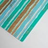 Vibrant striped wrapping paper with the phrase "a little treat..." in playful script, perfect for gift-giving occasions, featuring turquoise, gold, and white colors.