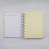 Neat planner with categorized tabs for invitations, reception, budget, attire, ceremony, featuring a spiral binding and organized sections for event planning.