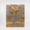 Shimmering gold and silver marbled gift bag with orange rope handles, perfect for luxurious packaging and special occasions. Elegant and eye-catching design ideal for retail and gifting.
