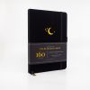 Black notebook with moon and stars design, ideal for journaling and note-taking.