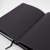 Minimalist black dot grid journal open on white background, perfect for note-taking, sketching, or journaling at The Wraperie. Stylish, functional, ideal for daily writing or creative projects.