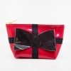 Shiny red cosmetic bag with a black glittery bow and black cross design, perfect for makeup and accessories. Elegant, festive, and stylish accessory for travel or gift-giving.