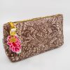 Elegant floral-patterned clutch bag with gold zipper and decorative charm, perfect for stylish accessories and party essentials.