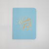 Wanderlust journal with a light blue cover and elegant orange calligraphy, perfect for travel enthusiasts and journal lovers.