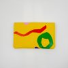 Vibrant yellow wrap pouch with colorful abstract shapes, perfect for storing wraps, snacks, or personal essentials at The Wraperie. Stylish and functional accessory for food lovers.