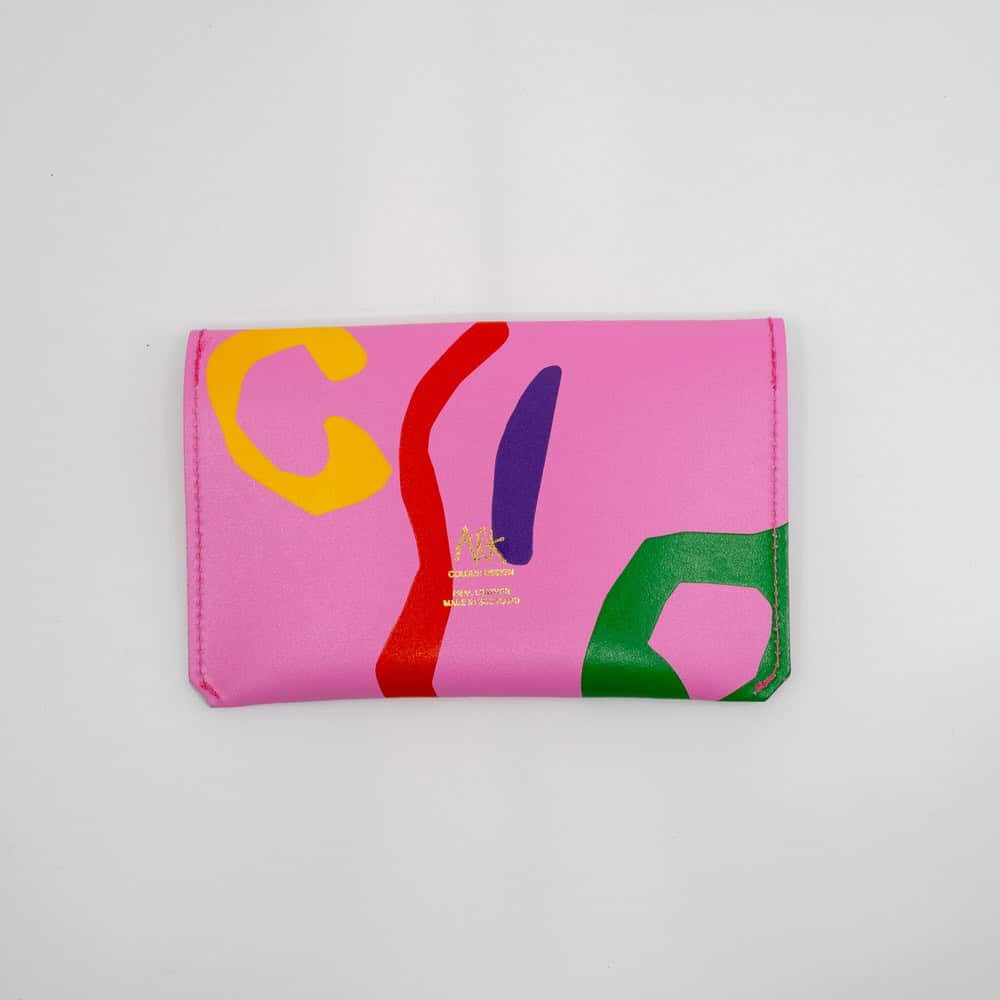 Vibrant pink designer clutch with colorful abstract print, perfect for fashion-forward accessories and statement styles.