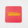Bright pink coaster with the humorous phrase "I am definitely not a... CHOCOHOLIC" in yellow text, perfect for chocolate lovers and coffee shops.