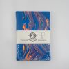 Vibrant blue and orange marbled sketchbook with white band label, perfect for artistic projects, note-taking, and creative journaling. Durable hardcover design for artists and students.