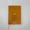 Aesthetic orange snakeskin-patterned hardcover notebook with gold foil "Bestseller" text and a laptop illustration, featuring a ribbon bookmark at the bottom.