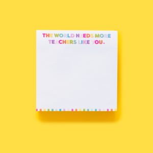 Bright white notepad with colorful lettering that says "The world needs more teachers like you" on a vibrant yellow background, celebrating educators and inspiring appreciation.