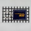 Bold navy blue keychain wallet with yellow text reading "I am definitely not... MESSY" on a checkered black and white background.