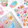 Bright, colorful cat-themed stickers and decals with playful designs including coffee cups, cupcakes, and hearts, perfect for customizing laptops, notebooks, and planners.