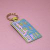 Brightly colored adhesive house-shaped keychain with a metal ring on a pink background, perfect for home decor or accessories. Stylish and playful, ideal for keys or bags.
