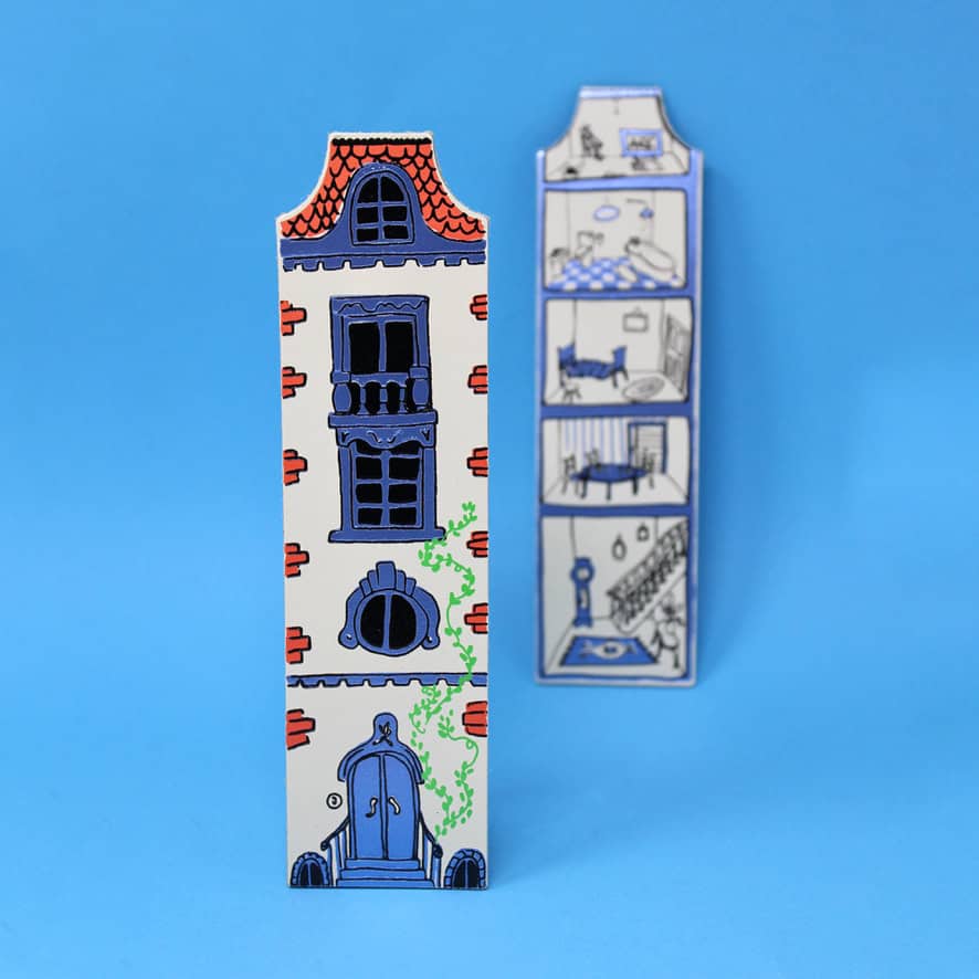 Charming illustrated house-shaped cardboard box with detailed architectural features, vibrant colors, and a playful design, perfect for quirky packaging or creative gift wrapping.