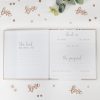 The Wraperie wedding guest book with elegant calligraphy, surrounded by rose gold 