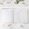 Budget planner and notes notebook with a white cover, open to pages for writing notes and budgeting, surrounded by decorative 