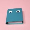 Colorful cartoon-themed notebook with goofy eyes on a pink background, perfect for kids' stationery, fun writing accessories, or playful office supplies. Bright, whimsical design appeals to children and creatives alike.