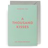 Bright happy birthday card with the message "A Thousand Kisses" in pink text on a mint green background, perfect for celebrating special moments with loved ones.