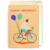 Bright birthday greeting card with a colorful illustration of a man riding a bicycle with a dog in the basket, balloons tied to the bike, and "Happy Birthday" message. Perfect for celebrating special occasions.