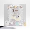Bright greeting card with "Congratulations Twins" message, featuring a whimsical pastel-colored nursery tent illustration with moon, clouds, and bunny accents, perfect for celebrating new twin arrivals.