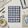 Blue gingham-patterned gift wrap from The Wraperie, ideal for special events and creative packaging.