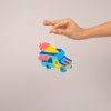 Colorful ice cream truck paper ornament hanging from a hand, vibrant dessert-themed decoration for food truck parties or summer events.