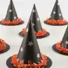 Party hat decorations, black cone-shaped party hats with silver stars and orange fringe trim, perfect for birthday celebrations and themed parties, festive party supplies.