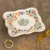 Bright floral-patterned jewelry dish with inspirational quote, featuring colorful flower border and delicate ring, perfect for storing rings and small accessories.
