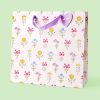 Pink floral gift bag with purple ribbon handle, decorated with colorful botanical illustrations, perfect for special occasions, gift-giving, and celebrations at The Wraperie.