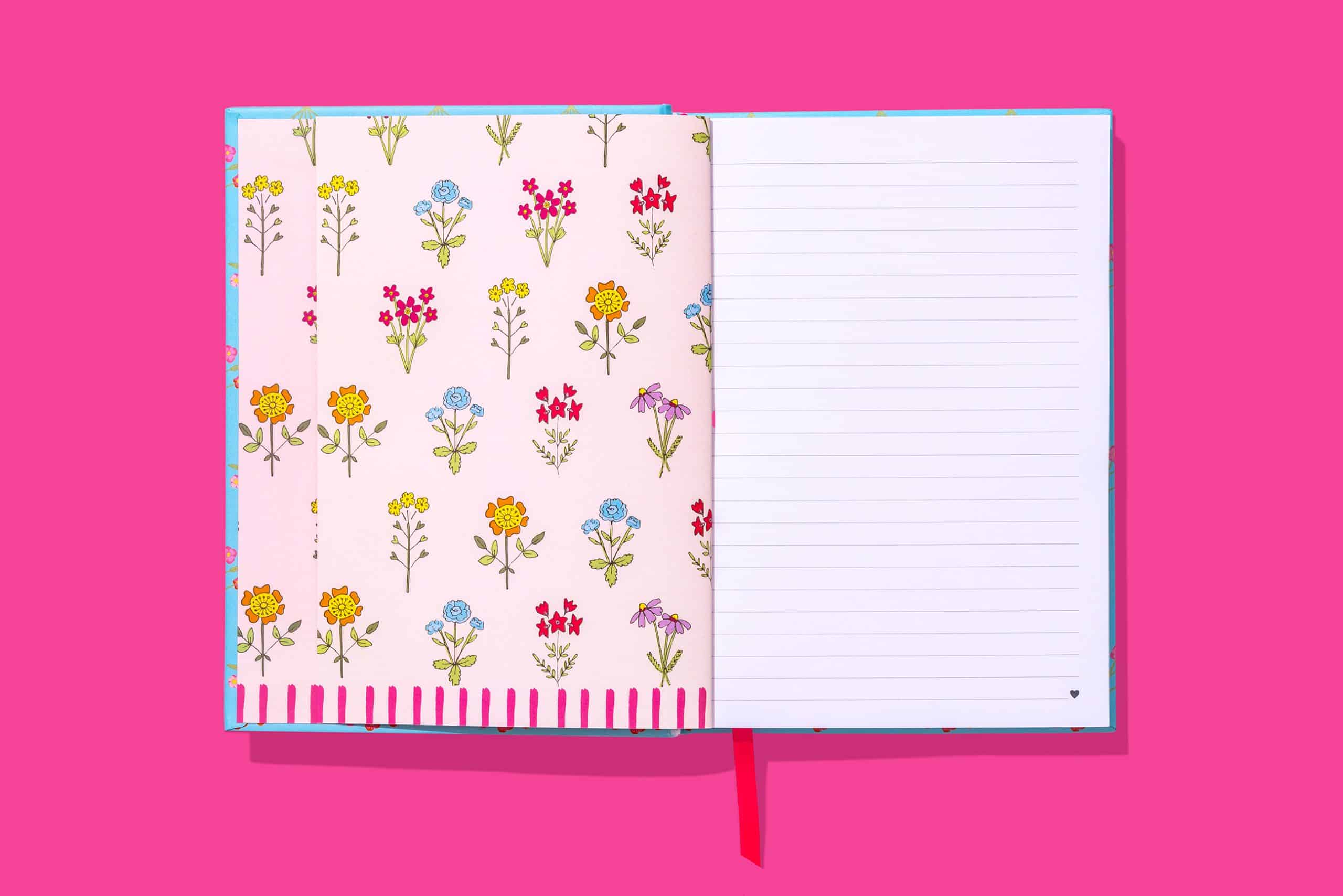 Colorful floral patterned notebook with pink, blue, yellow, red, and purple flowers on the pages, perfect for journaling or note-taking.