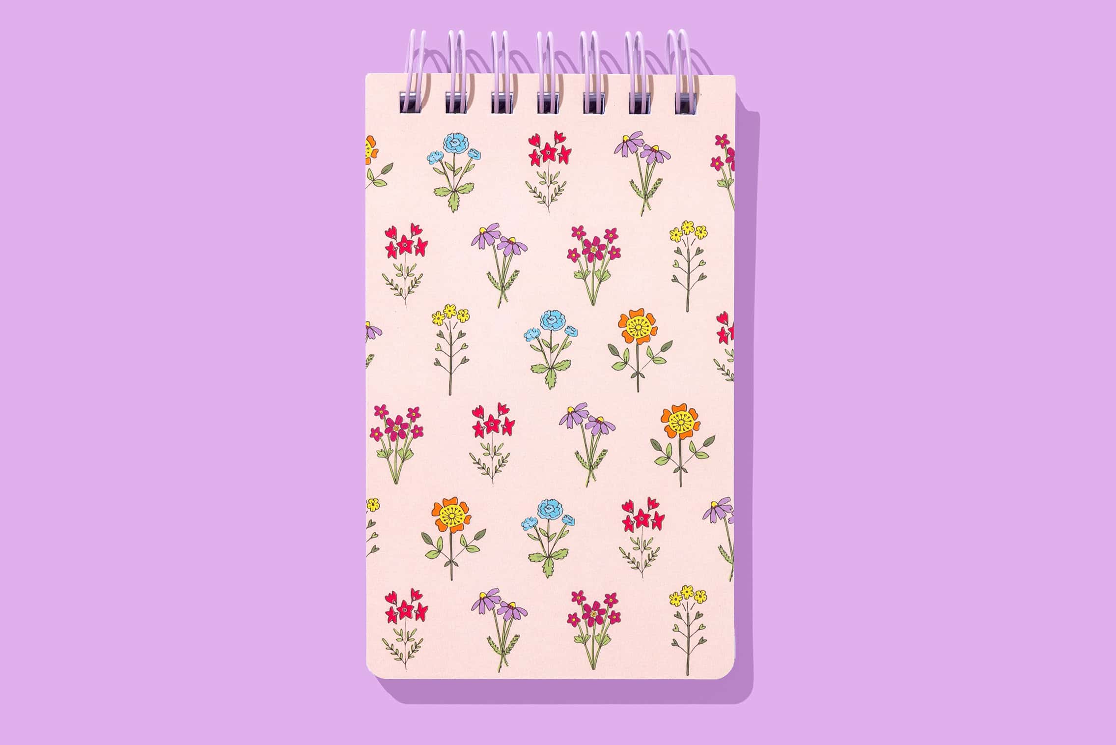 Colorful floral patterned notepad with spiral binding for creative notes and journaling.