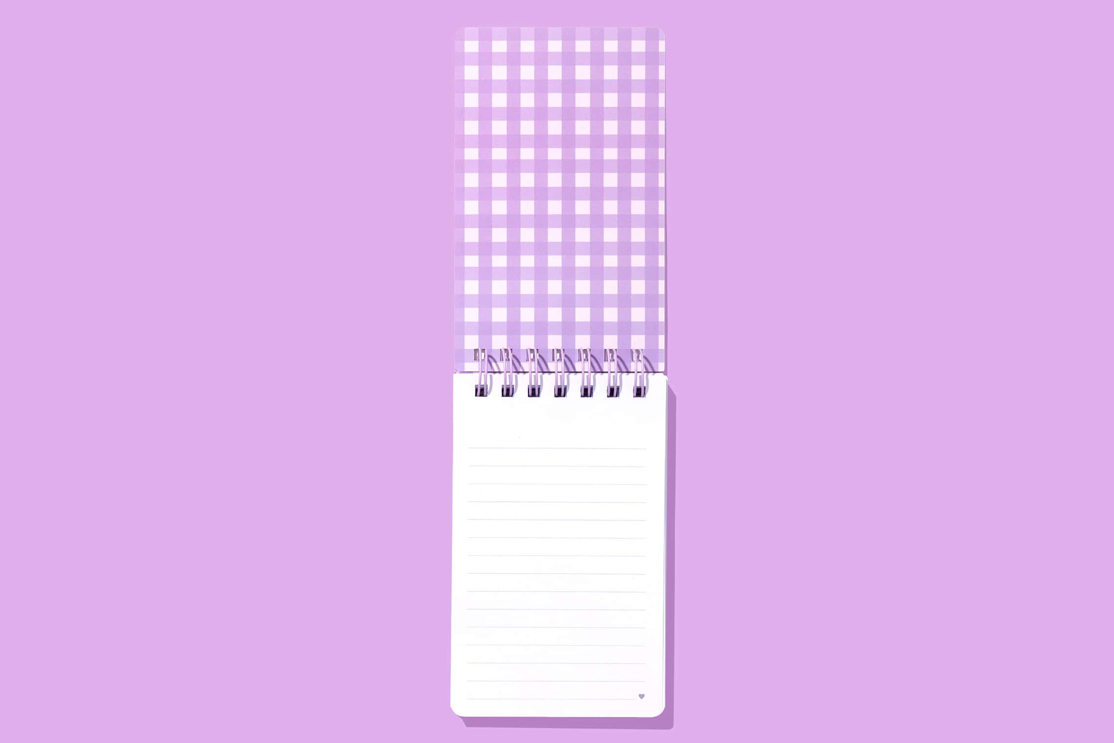 Mini purple checkered spiral notepad with lined pages, perfect for note-taking and journaling, on a matching purple background.