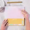 Organized planner with pastel pink and yellow colors, featuring 