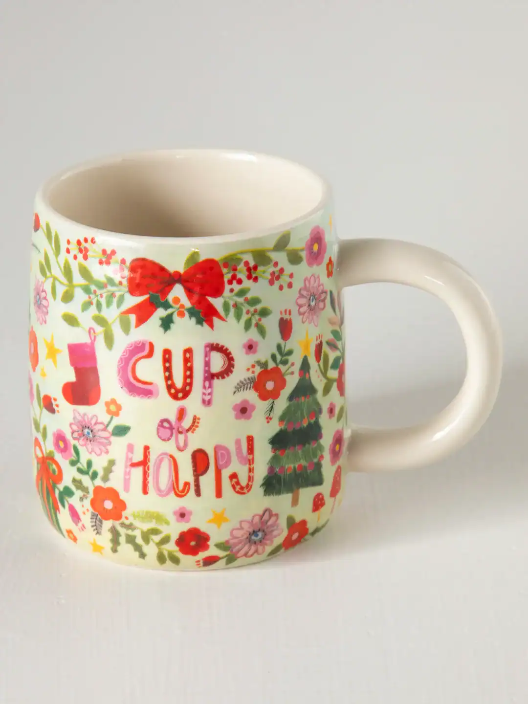 Colorful holiday-themed ceramic mug featuring festive words "Joy & Happy" with Christmas tree and decorative floral patterns, ideal for holiday celebrations and gifting.