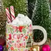 Peppermint hot chocolate mug with marshmallows, candy canes, Christmas ornaments, and festive decorations for holiday celebration.
