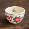Colorful ceramic bowl with floral patterns and an inspirational message, perfect for home decor or gifting.
