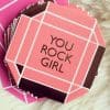 Cute pink gift box with geometric white lines and the message "You Rock Girl" for empowering women and girls. Perfect for celebrations, motivational gifting, and special occasions.