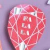 Colorful heart-shaped food wrapper from The Wraperie with "FALALA" text, pink and white geometric design, perfect for custom wraps and catering presentations.