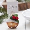 Festive holiday place card holder with decorative red berries and holly leaves, perfect for Christmas table settings at The Wraperie.