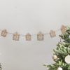 String of decorative wooden house ornaments hanging on a wall for Christmas holiday decor.