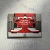 Colorful birthday card featuring a red race car design with the message “Happy Birthday Champ” perfect for racing or car enthusiasts.