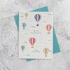 Colorful hot air balloon greeting card with "Bon Voyage" message, featuring textured paper design, clouds, and small stars on a light background, ideal for travel-themed occasions.