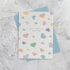 Colorful embossed heart get well soon card with pastel tones on textured white background.